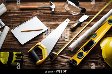 Construction and renovation concept. Building contractor tools on wooden table. Top view. Stock Photo