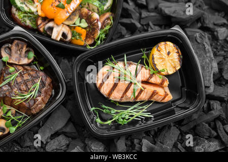 Set of grilled food in to go black boxes on coal Stock Photo