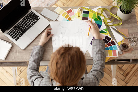 Talented tailor designing new collection, drawing sketches Stock Photo