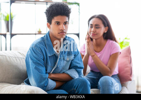 Teenagers having relationship difficulties. Boy sulking to his upset girlfriend Stock Photo