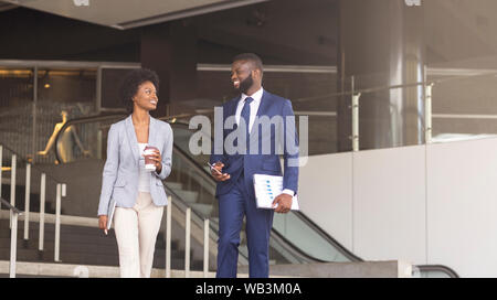 Two african american employees leaving office building for coffee break Stock Photo