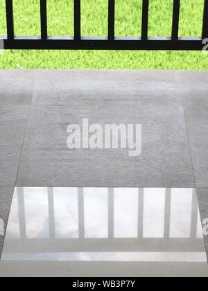 Vertical shot of ceramic floor reflecting the metal fence Stock Photo