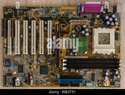 TIMISOARA, ROMANIA - DECEMBER 02, 2018: Close-up of an ASUS motherboard on a wooden table. CPU socket 370. Top view. Stock Photo