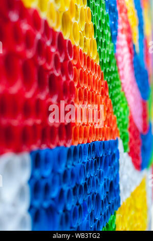 Close-up on plastic bottle caps. Art made of multi colored bottle caps. Stock Photo