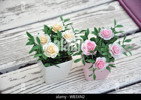 Artificial flowers in pots on the table. Table setting Stock Photo