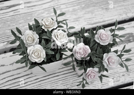 Artificial flowers in pots on the table. Background Stock Photo