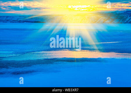idyllic winter, scenery with sun over frozen lake Stock Photo