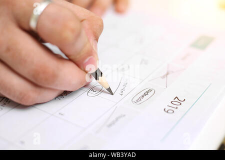 Picture of Man holding Calendar and marking on date. Isolated on white background. Stock Photo