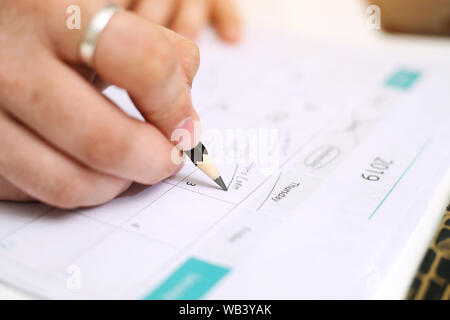 Picture of Man holding Calendar and marking on date. Isolated on white background. Stock Photo