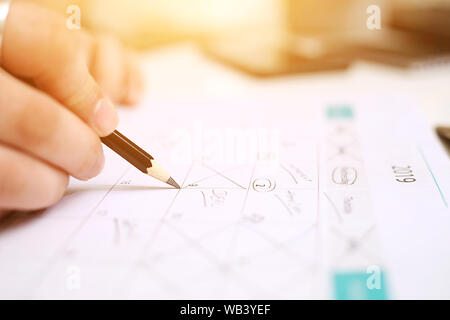 Picture of Man holding Calendar and marking on date. Isolated on white background. Stock Photo