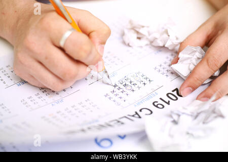 Picture of Man holding Calendar and marking on date. Isolated on white background. Stock Photo