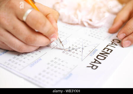 Picture of Man holding Calendar and marking on date. Isolated on white background. Stock Photo