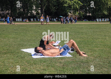 London, UK. 24th August 2019.  People sunbathing in Green Park on a hot sunny day  as ta mini heatwave is  forecast with temperatures soaring during the bank holiday weekend  Credit: amer ghazzal/Alamy Live News Stock Photo
