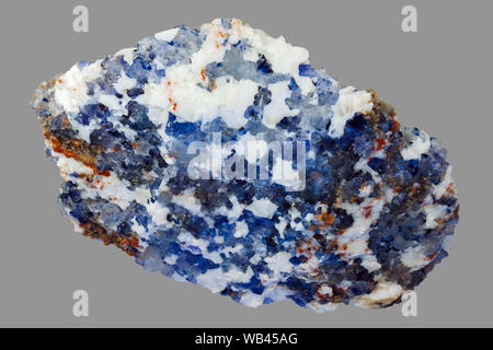 white and blue piece of halite mineral, natural crystalline rock salt, isolated on gray background Stock Photo