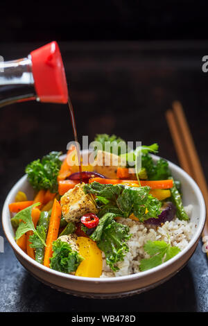 Kale, peppers, green beans, red onion, rice, basil tofu stir fry Stock Photo