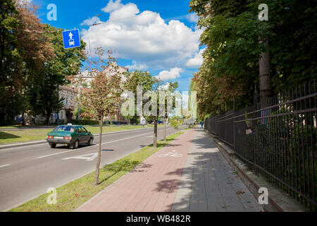 Protected bike lane between parking lane and sidewalk on city street Stock Photo