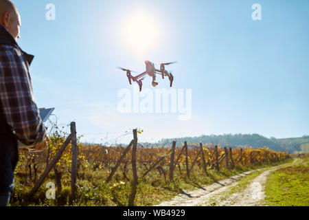 Young man control modern drone in air Stock Photo