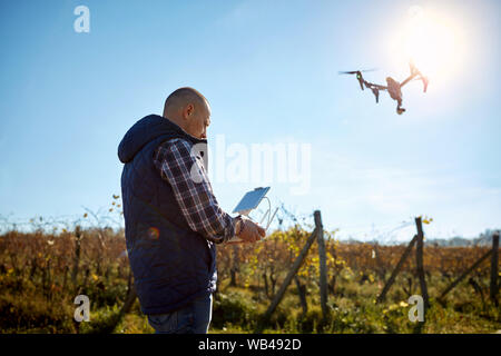 Man from ground manage drone at sky Stock Photo
