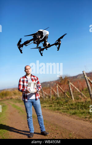 Young male wireless manage drone from ground Stock Photo