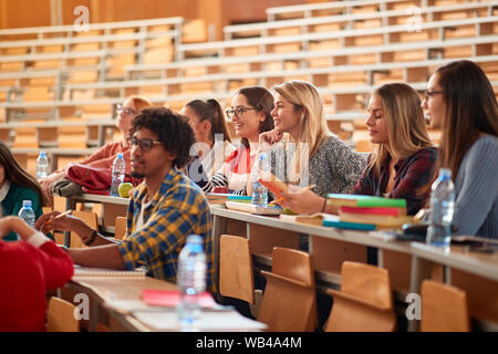 Diverse group of young students studying together at college on auditorium Stock Photo