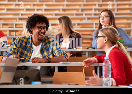 Smiling young friends studying together at university campus Stock Photo
