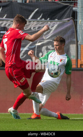 Augsburg, Germany. 24th Aug, 2019. Soccer: Bundesliga, FC Augsburg - 1st FC Union Berlin, 2nd matchday in the WWK-Arena. Stephan Lichtsteiner from Augsburg (r) and Berlin's Christopher Lenzliefer in a duel. Credit: Stefan Puchner/dpa - IMPORTANT NOTE: In accordance with the requirements of the DFL Deutsche Fußball Liga or the DFB Deutscher Fußball-Bund, it is prohibited to use or have used photographs taken in the stadium and/or the match in the form of sequence images and/or video-like photo sequences./dpa/Alamy Live News Stock Photo