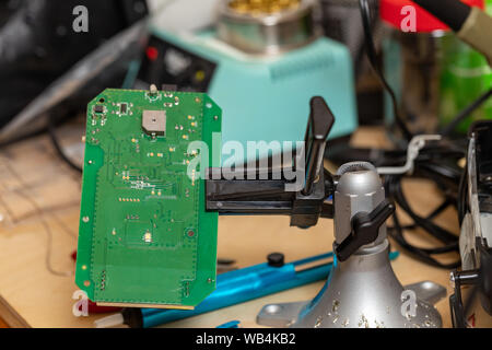 Printed circuit board in vice on workbench for repair Stock Photo