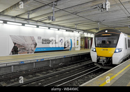 Farringdon Elizabeth Line Crossrail poster billboard & train on the tracks with woman driver at Farringdon Station in London England UK  KATHY DEWITT Stock Photo