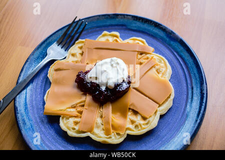 Norwegian brown cheese on a waffle with strawberry jam and sour cream Stock Photo