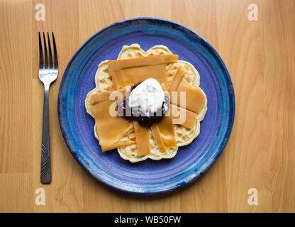 Norwegian Brown Cheese on a Waffle with Strawberry Jam and Soured Cream Stock Photo