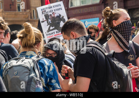 London, UK. 24th August 2019. Anti-fascists meet at Oxford St to oppose a protest at the BBC by Tommy Robinson supporters who claim he is in jail for journalism. He was sentenced to 9 months for 3 offences outside Leeds Crown Court which could have led to the collapse of a grooming gang trial, and has previous convictions for violence, financial and immigration frauds, drug possession and public order offences. Police kept the two groups apart. Robinson supporters were later joined by marchers from Trafalgar Square, and a larger group from Stand Up to Racism came to join Antifa. Peter Marshall Stock Photo