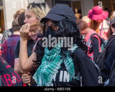 London, UK. 24th August 2019. Anti-fascists meet at Oxford St to oppose a protest at the BBC by Tommy Robinson supporters who claim he is in jail for journalism. He was sentenced to 9 months for 3 offences outside Leeds Crown Court which could have led to the collapse of a grooming gang trial, and has previous convictions for violence, financial and immigration frauds, drug possession and public order offences. Police kept the two groups apart. Robinson supporters were later joined by marchers from Trafalgar Square, and a larger group from Stand Up to Racism came to join Antifa. Peter Marshall Stock Photo