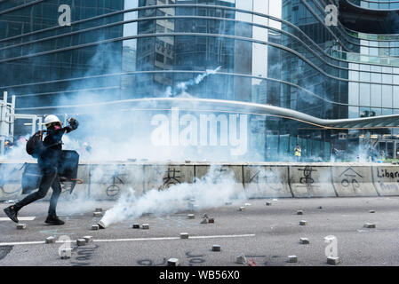A protester throws a canisters of tear gas back towards the police during the demonstration.Thousands of anti-government protesters marched in opposition to the extradition bill. Protesters eventually clashed with police, leading to widespread of police dispersal operations and multiple arrests. Stock Photo
