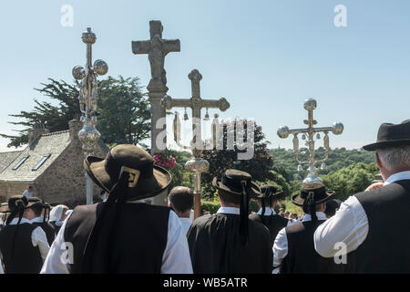 Breton Celebrants carrying processional crosses during the Pardon of Fire in the village of St. Jean du Doigt in Brittany, France. A Pardon is a typically Breton form of pilgrimage and one of the most traditional demonstrations of popular Catholicism in Brittany. Stock Photo