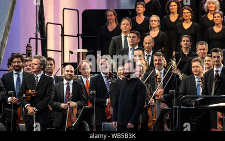 Berlin, Germany. 24th Aug, 2019. The Berliner Philharmoniker under the direction of the new chief conductor Kirill Petrenko (front, centre) will give a concert at the Brandenburg Gate. Credit: Paul Zinken/dpa/Alamy Live News Stock Photo