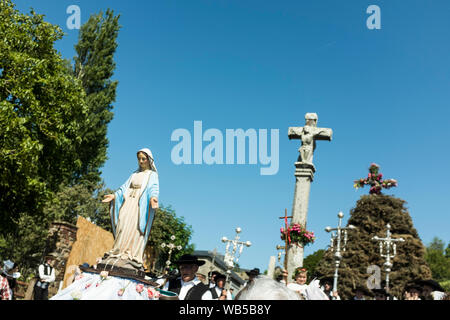 Looking up at a cross and a statue of the Virgin Mary during the Pardon of Fire in the village of St. Jean du Doigt in Brittany, France. A Pardon is a typically Breton form of pilgrimage and one of the most traditional demonstrations of popular Catholicism in Brittany. Stock Photo