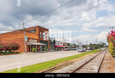 HUDSON, NC, USA- 14 AUGUST 2019: The Main Street, showing buildings, railroad track, and water tower in the distance. Stock Photo