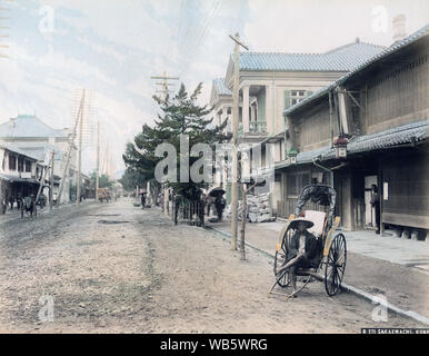 [ 1890s Japan - Japanese Rickshaw Puller Resting ] —   A rickshaw puller rests in his carriage on Sakaemachi in Kobe, Hyogo Prefecture.  19th century vintage albumen photograph. Stock Photo