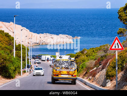 Camper car with bicycles driving in the highway road at Capo Testa in Santa Teresa Gallura at the Mediterranean Sea on Sardinia Island in Summer Italy Stock Photo