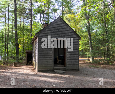 Replica of Henry David Thoreau’s little one-room cabin in the woods, with chimney and woodshed, at Walden Pond in the autumn. Concord, MA. Stock Photo