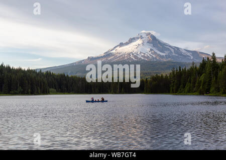 Trillium Lake, Mt. Hood National Forest, Oregon, United States of America - June 30, 2019: Family Canoeing in a beautiful lake with Hood Mountain in t Stock Photo