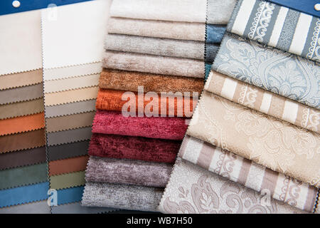 Assorted selection of fabric color swatches or samples for interior decorating with different textures and patterns in an overhead full frame backgrou Stock Photo