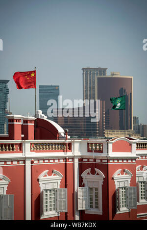 china and macau flags on chinese government headquarters building in downtown macau city Stock Photo