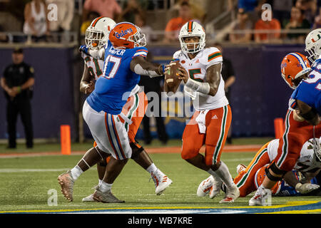 Orlando, Florida, USA. 24th August, 2019.  Miami Hurricanes quarterback Jarren Williams (15) gets pressured by Florida Gators defensive lineman Zachary Carter (17) during 2nd half of the Camping World Kickoff between Miami Hurricanes and Florida Gators. Florida defeated Miami 24-20 at Camping World Stadium in Orlando, Fl. Romeo T Guzman/CSM Credit: Cal Sport Media/Alamy Live News Stock Photo