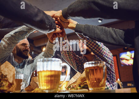 Beer friends free time concept. Cheerful friends with glasses and beer in the bar. Stock Photo