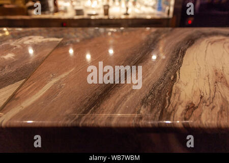 Bar counter made of gold-colored marble with lights reflections Stock Photo