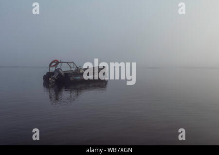 Motor boat in foggy morning near Fort William on the lake. Stock Photo