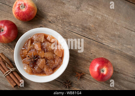 Homemade Apple Chutney (apple jam, marmalade, chunky sauce) with cinnamon, anise and apples on wooden background, copy space. Traditional autumn apple Stock Photo