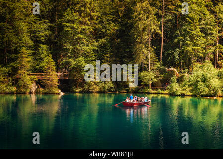 Tourists taking a boat trip on Blausee Lake in Switzerland