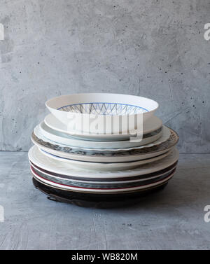 Clean dishes on the table in a stack on a gray background Stock Photo